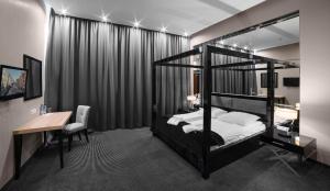 埃尔布隆格Focus Hotel Premium Elbląg的一间卧室配有一张黑色双层床、一张书桌和一张书桌。