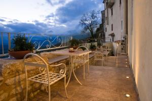 PiciniscoAlbergo Diffuso Sotto Le Stelle的阳台配有桌椅,享有海景。