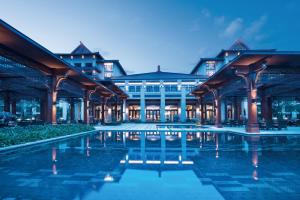 昆明昆明古滇名城皇冠假日酒店的一座大型建筑,前面设有一个游泳池