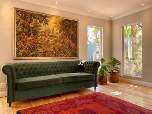 比勒陀利亚穆利大街137号旅馆的客厅配有绿色沙发和大画