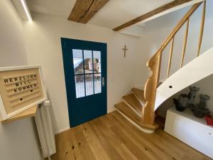 黑尔博尔茨海姆Traumhaft wohnen im Haus Blum的一条带有蓝色门的楼梯,墙上有十字架