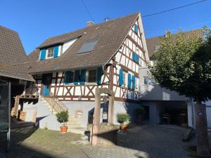 黑尔博尔茨海姆Traumhaft wohnen im Haus Blum的一座带蓝色百叶窗的古老建筑和一座房子