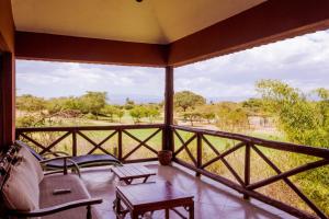 奈瓦沙Ol-Kine Cottage at The Great Rift Valley Lodge & Golf Resort Naivasha的享有热带稀树草原景致的门廊上设有屏风