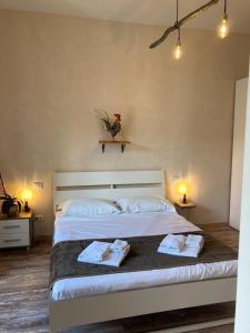 巴韦诺Locanda Il Gallo的一间卧室配有一张大床和两条毛巾