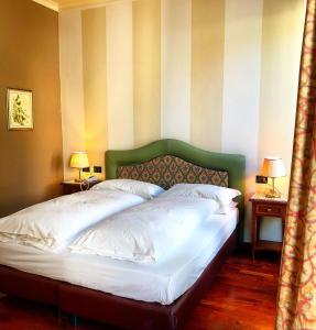 塞斯托拉Hotel Roma的卧室内一张带绿色床头板的床