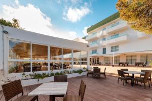 卡拉隆加Hotel El Pinar的享有带桌椅的建筑的外部景色。