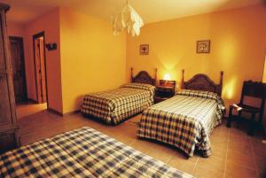 Hoyorredondo欧亚雷当多小径酒店的黄色墙壁客房的两张床