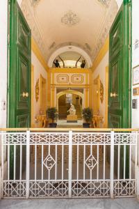 瓦莱塔Casa Rocca Piccola B&B的一间设有绿门的客房和一个带雕像的楼梯
