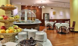 夸尔托达尔蒂诺威尼斯东部皇冠广场酒店的餐厅里一张带盘子和水果的桌子
