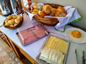 戈亚斯州上帕莱索Pousada Rancho dos Ipês的一张桌子,上面有一篮面包和一盘食物