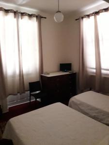 丰沙尔彭邵米拉索尔酒店的一间卧室配有两张床和一张带笔记本电脑的书桌