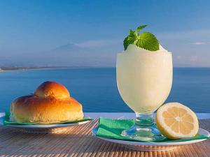 卡塔尼亚维拉吉奥阿尔伯格国际拉普拉加酒店的一杯酒,紧挨着一盘食物