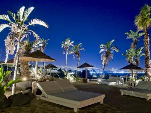 卡塔尼亚维拉吉奥阿尔伯格国际拉普拉加酒店的棕榈树和遮阳伞及海洋度假村