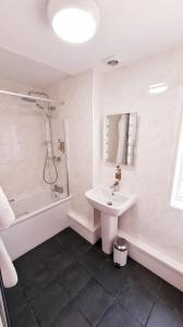 法纳姆法纳姆豪斯酒店的白色的浴室设有水槽和淋浴。