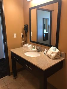 迈诺特Quality Inn & Suites的一间带水槽和大镜子的浴室