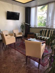 利多迪耶索罗棕榈滩酒店的客厅配有椅子、桌子和电视