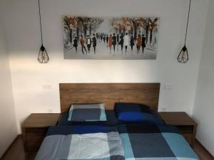 马里博尔Apartment Šelih的卧室配有一张床,墙上挂有绘画作品