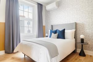 伦敦Sonder Camden Road的一间卧室配有白色床和蓝色枕头