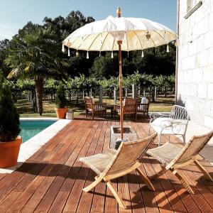 Santa Cristina de CobresOs Areeiros Turismo Rural & Bodega的庭院配有桌椅和遮阳伞。