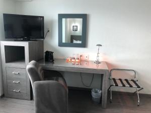 墨西哥城阿罗普维尔酒店的客房设有书桌、电视和椅子