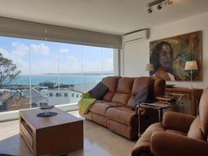 戈登湾24 Gordonia, Sleeps 7, Beach Front condo - Load-shedding friendly with Solar Power and battery backup的带沙发和大窗户的客厅