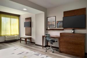 布拉塞尔顿La Quinta Inn & Suites by Wyndham Braselton的酒店客房配有书桌和电视。