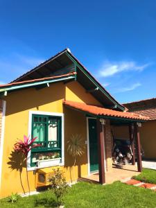 弗洛里亚诺波利斯Casa Chale 10 Florianópolis的黄色的房子,有窗户和院子