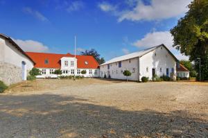 JelsPension Slotsgaarden jels的一座白色的大建筑,有橙色的屋顶