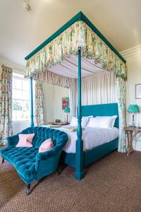 莫尔顿The Talbot, Malton, North Yorkshire的卧室内的蓝色天蓬床和蓝色沙发