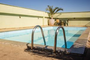塞蒂拉瓜斯Riviera Palace Hotel的一座游泳池,旁边设有两个金属栏杆