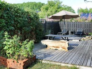 诺尔赫鲁普9 person holiday home in Hadsund的木甲板上配有野餐桌和遮阳伞