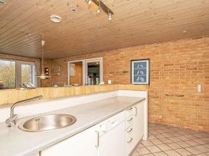 灵克宾7 person holiday home in Ringk bing的厨房设有水槽和砖墙