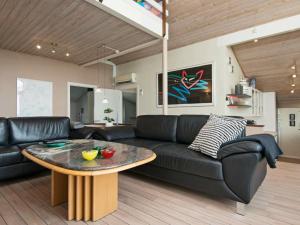 埃贝尔托夫特10 person holiday home in Ebeltoft的客厅配有黑色沙发和桌子
