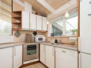埃贝尔托夫特6 person holiday home in Ebeltoft的厨房配有白色橱柜和水槽