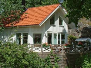 瓦尔德马什维克4 person holiday home in VALDEMARSVIK的一座白色的小房子,拥有橙色的屋顶