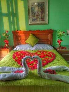 埃尔富埃尔特Hotel Santa Elena的两个天鹅躺在花朵上盖着的床上