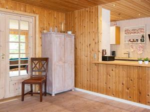 格莱斯堡6 person holiday home in Glesborg的厨房配有椅子和木墙