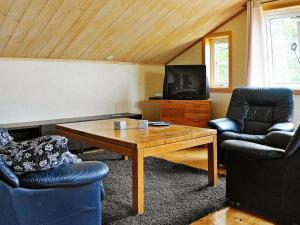 卢恩斯基尔Four-Bedroom Holiday home in S-Uddvalla的客厅配有两把椅子、一张桌子和一台电视