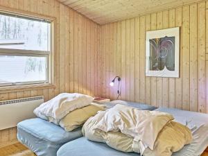 维斯特索马肯6 person holiday home in Aakirkeby的一间卧室设有两张床和窗户。