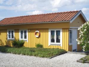 斯泰农松德One-Bedroom Holiday home in Stenungsund的棕色屋顶的黄色房子