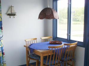 斯泰农松德One-Bedroom Holiday home in Stenungsund的餐桌,配有三把椅子和蓝桌布