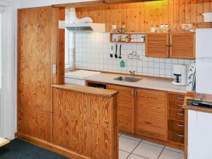 斯瓦讷克Two-Bedroom Holiday home in Svaneke 4的一个带木制橱柜和水槽的厨房