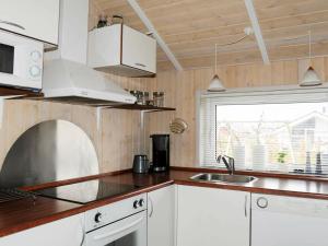 ÅrøsundHoliday Home Raade III的厨房配有白色橱柜、水槽和窗户。