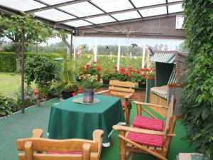 奥斯特巴德里克Charming Apartment in Rerik with Fenced Garden的庭院配有桌椅和鲜花
