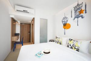 芭东海滩卢巴普吉岛芭东旅舍的一间带白色床的卧室和一间房间