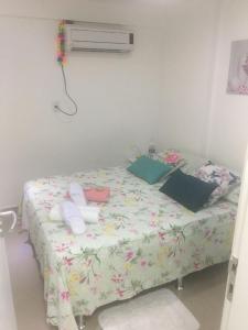 累西腓Lindo Ap 101 Quadra do Mar c Garagem的一间卧室配有一张带花卉棉被的床