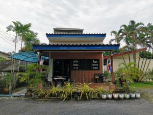 Ban NaiNestvilla Khok-kloi Phang-nga的蓝色屋顶和植物的小建筑