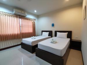 Ban NaiNestvilla Khok-kloi Phang-nga的一间卧室设有两张带白色床单的床和窗户。
