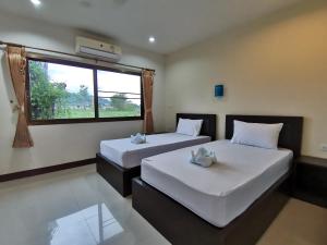 Ban NaiNestvilla Khok-kloi Phang-nga的带窗户的客房内的两张床