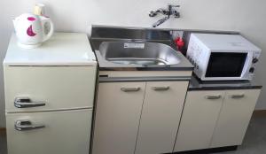 Hukueコンドミニアムホテル　Stay inn Blue room302的一间带水槽和微波炉的小厨房
